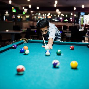 stylish-arabian-man-wear-jeans-playing-pool-billiard-bar